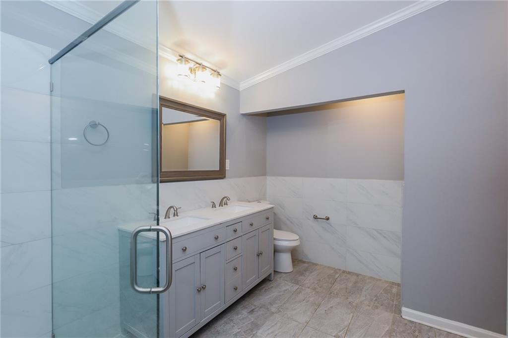 1277 Goodwin Road Northeast, Unit 1277 Atlanta, GA 30324 - Photo 12 of 15 a bathroom with a double vanity sink toilet and mirror