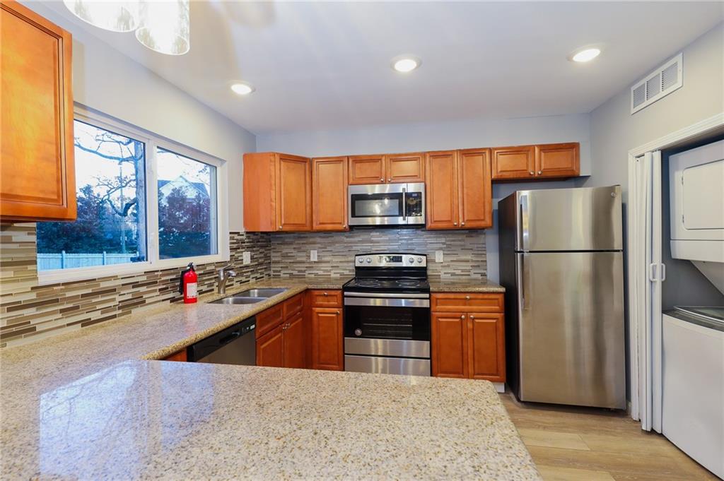 1277 Goodwin Road Northeast, Unit 1277 Atlanta, GA 30324 - Photo 6 of 15 a kitchen with stainless steel appliances granite countertop a refrigerator stove top oven and sink