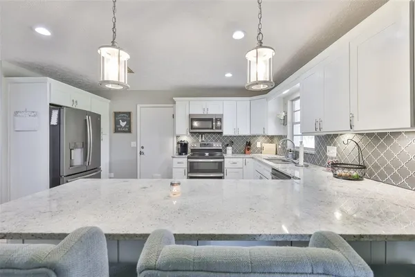 a kitchen with stainless steel appliances granite countertop a sink a stove and a center island