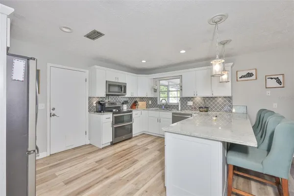 a kitchen with a sink white cabinets and stainless steel appliances