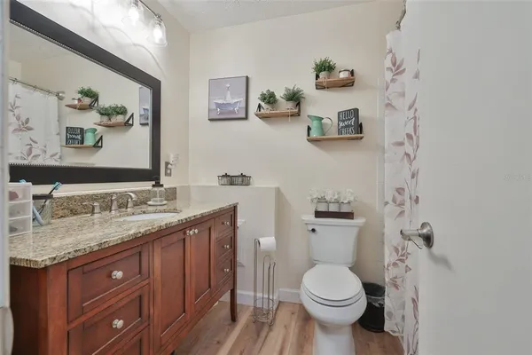 a bathroom with a granite countertop toilet sink and a mirror