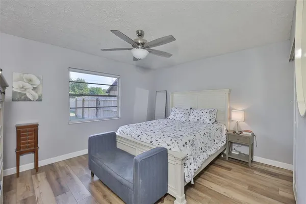 a bedroom with a bed chandelier and a window