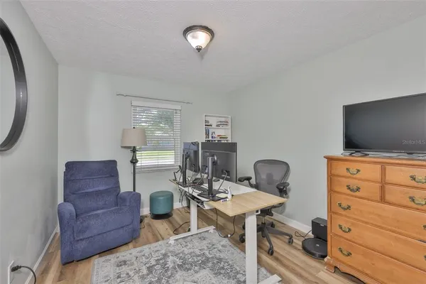 a living room with furniture a flat screen tv a rug and a window