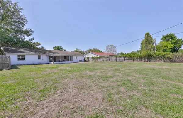 a front view of house with yard and trees in the background