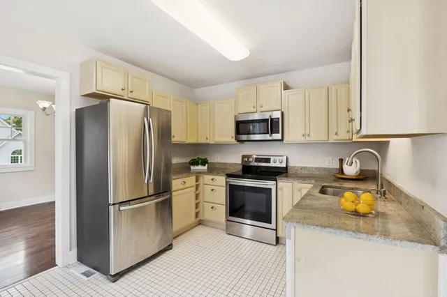 a kitchen with granite countertop a refrigerator stove and microwave