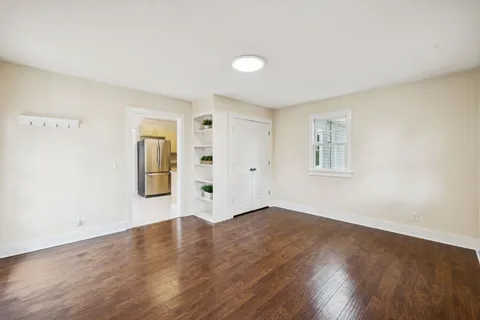 a view of an empty room with wooden floor