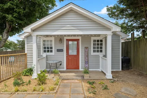 a front view of a house with a garden and yard