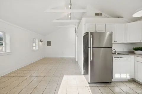 a kitchen with a refrigerator a stove top oven and cabinets