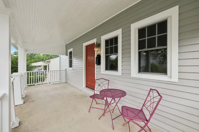 a view of a house with a floor to ceiling window and wooden fence