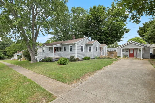 a front view of a house with a garden and trees