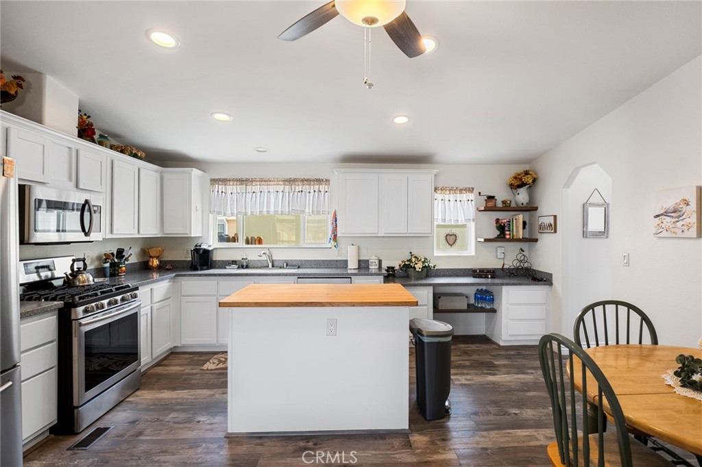 21621 Sandia Road, Unit 128 Apple Valley, CA 92308 - Photo 21 of 41 a kitchen with stainless steel appliances granite countertop a stove top oven a sink dishwasher a dining table and chairs with wooden floor
