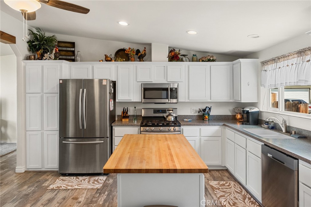 21621 Sandia Road, Unit 128 Apple Valley, CA 92308 - Photo 23 of 41 a kitchen with wooden cabinets and stainless steel appliances