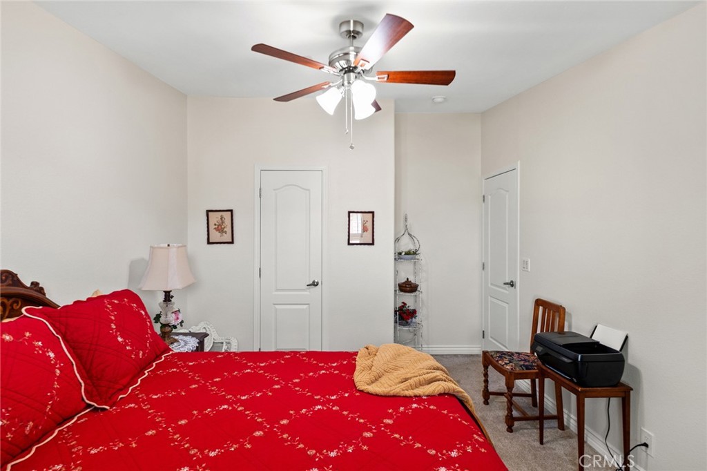 21621 Sandia Road, Unit 128 Apple Valley, CA 92308 - Photo 36 of 41 a bedroom with a bed and a chandelier