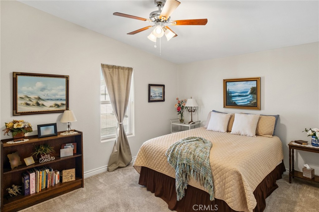21621 Sandia Road, Unit 128 Apple Valley, CA 92308 - Photo 37 of 41 a bedroom with a bed a book shelf and a book shelf