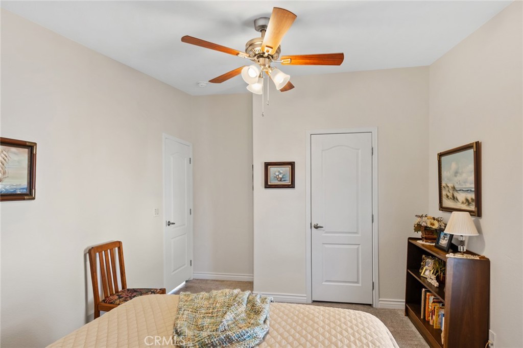 21621 Sandia Road, Unit 128 Apple Valley, CA 92308 - Photo 38 of 41 a bedroom with a bed and a chandelier