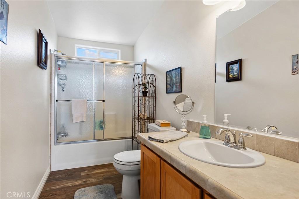 21621 Sandia Road, Unit 128 Apple Valley, CA 92308 - Photo 39 of 41 a bathroom with a granite countertop sink toilet mirror vanity and shower
