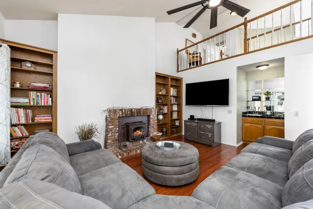 a living room with furniture a flat screen tv and a fireplace