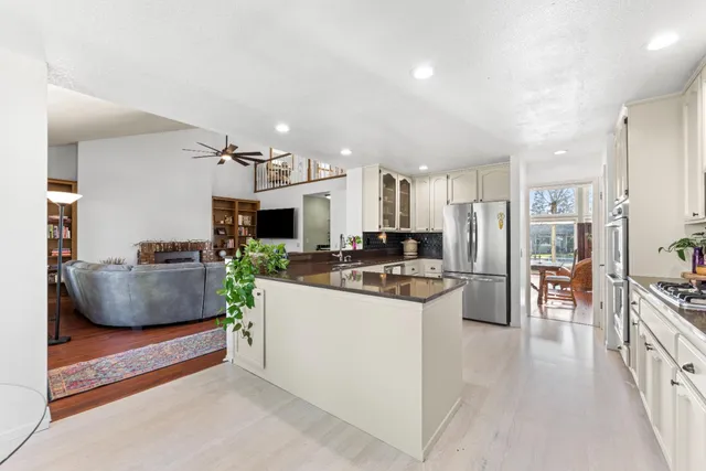 a large kitchen with stainless steel appliances kitchen island granite countertop a lot of counter top space and cabinets