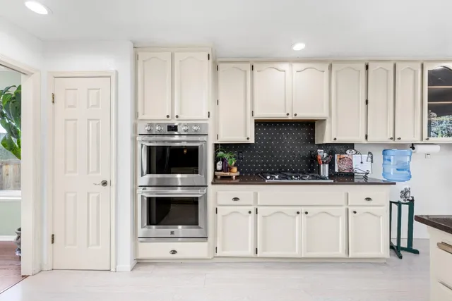 a kitchen with white cabinets and stainless steel appliances