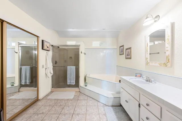 a bathroom with a tub sink shower and mirror