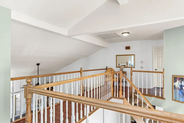 a view of staircase with railing and a rug