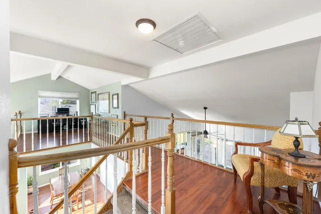 a view of a hallway with furniture and wooden floor