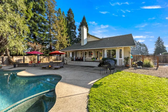 a view of a house with swimming pool and sitting area