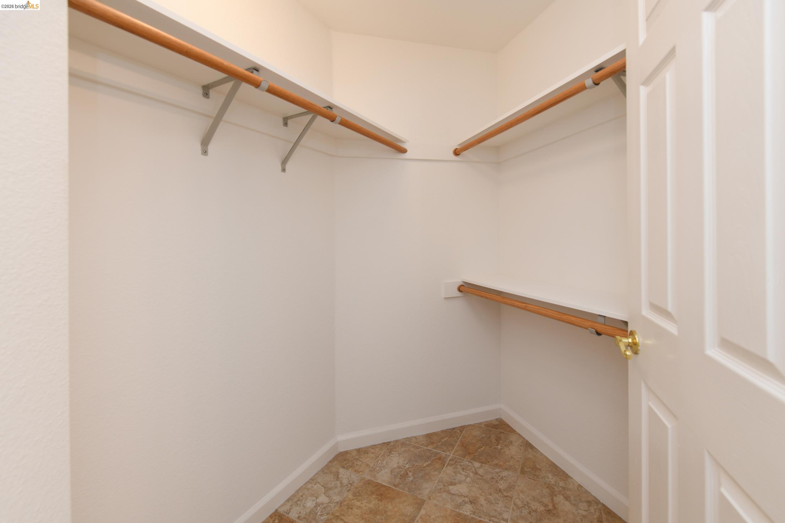 512 Burdick Drive Bay Point, CA 94565 - Photo 28 of 50 Walk-in closet with beige tile flooring, white painted walls, and built-in wooden rods and shelving