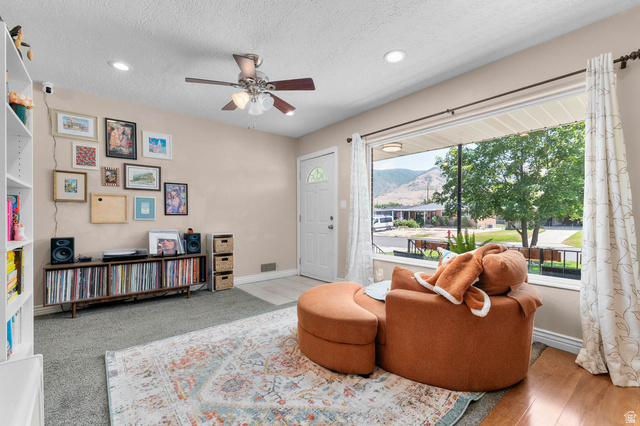 1489 North 400 West Bountiful, UT 84010 - Photo 6 of 47 Living area featuring a large picture window, ceiling fan with integrated lighting, recessed lighting, and mixed flooring with carpet and wood-finish sections