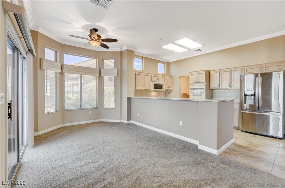 1904 Hot Oak Ridge Street Las Vegas, NV 89134 - Photo 20 of 74 Kitchen featuring white appliances, crown molding, light countertops, light colored carpet, and a ceiling fan