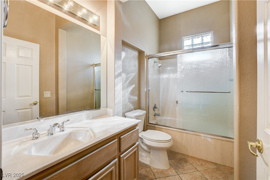 1904 Hot Oak Ridge Street Las Vegas, NV 89134 - Photo 28 of 74 Bathroom with bath / shower combo with glass door, vanity, and light tile patterned flooring