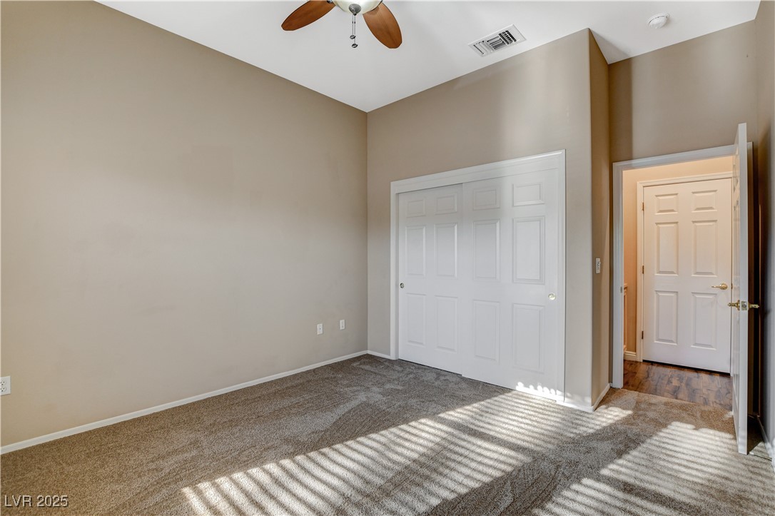 1904 Hot Oak Ridge Street Las Vegas, NV 89134 - Photo 32 of 74 Unfurnished bedroom featuring carpet, a closet, and a ceiling fan
