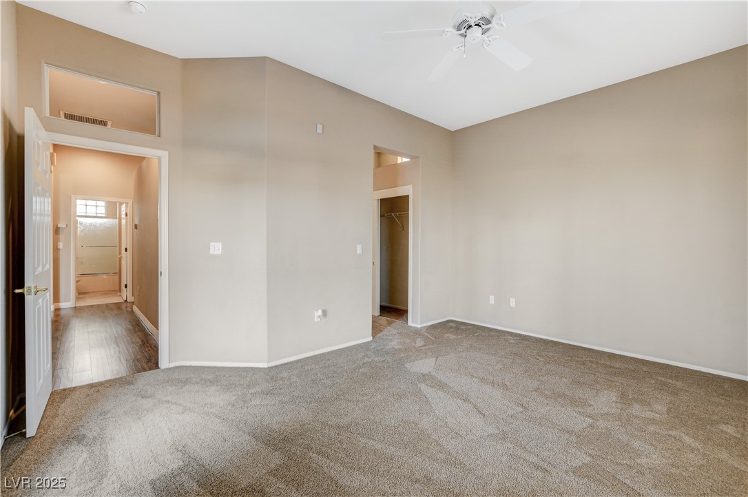 1904 Hot Oak Ridge Street Las Vegas, NV 89134 - Photo 36 of 74 Unfurnished bedroom featuring light colored carpet, a walk in closet, and a ceiling fan