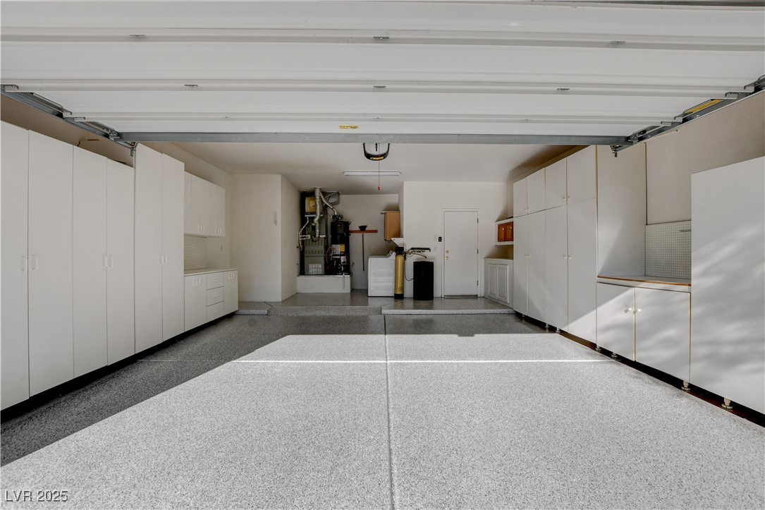 1904 Hot Oak Ridge Street Las Vegas, NV 89134 - Photo 40 of 74 Garage with strapped water heater, washing machine and clothes dryer, and heating unit