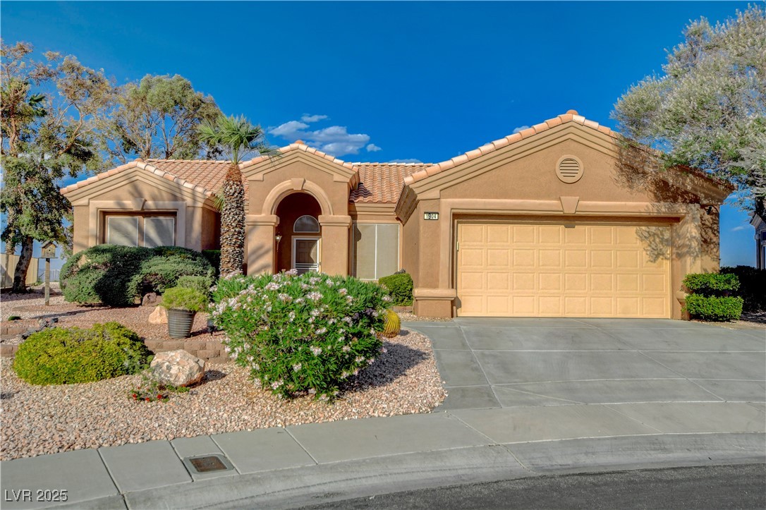 1904 Hot Oak Ridge Street Las Vegas, NV 89134 - Photo 5 of 74 Mediterranean / spanish-style house with a tile roof, stucco siding, concrete driveway, and an attached garage