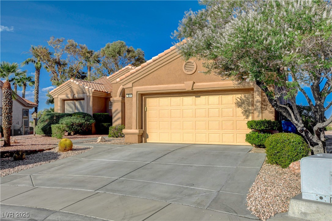 1904 Hot Oak Ridge Street Las Vegas, NV 89134 - Photo 6 of 74 Mediterranean / spanish-style house with a tiled roof, stucco siding, driveway, and a garage