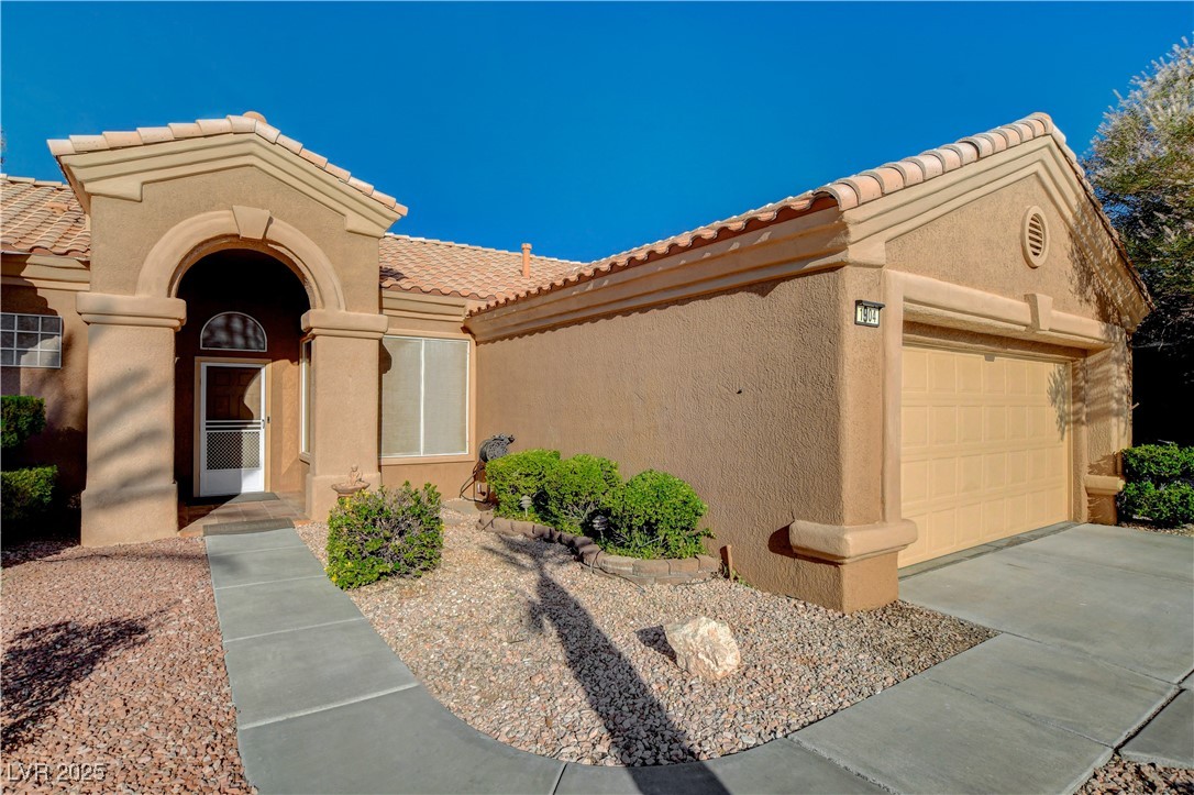 1904 Hot Oak Ridge Street Las Vegas, NV 89134 - Photo 7 of 74 Mediterranean / spanish home with a tiled roof, a garage, and stucco siding