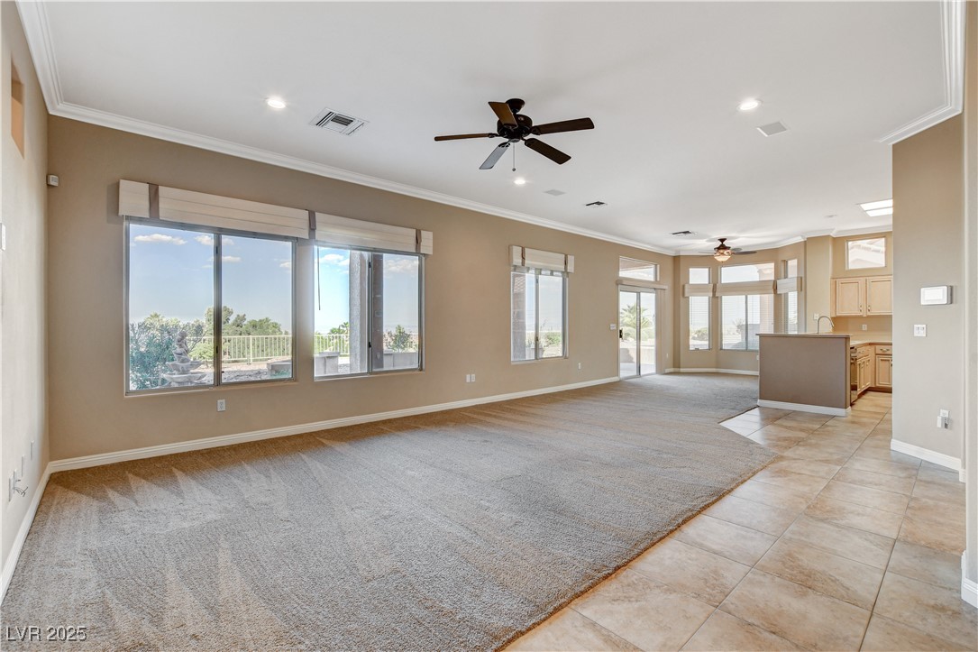 1904 Hot Oak Ridge Street Las Vegas, NV 89134 - Photo 9 of 74 Unfurnished living room featuring ornamental molding, a ceiling fan, light carpet, recessed lighting, and light tile patterned flooring