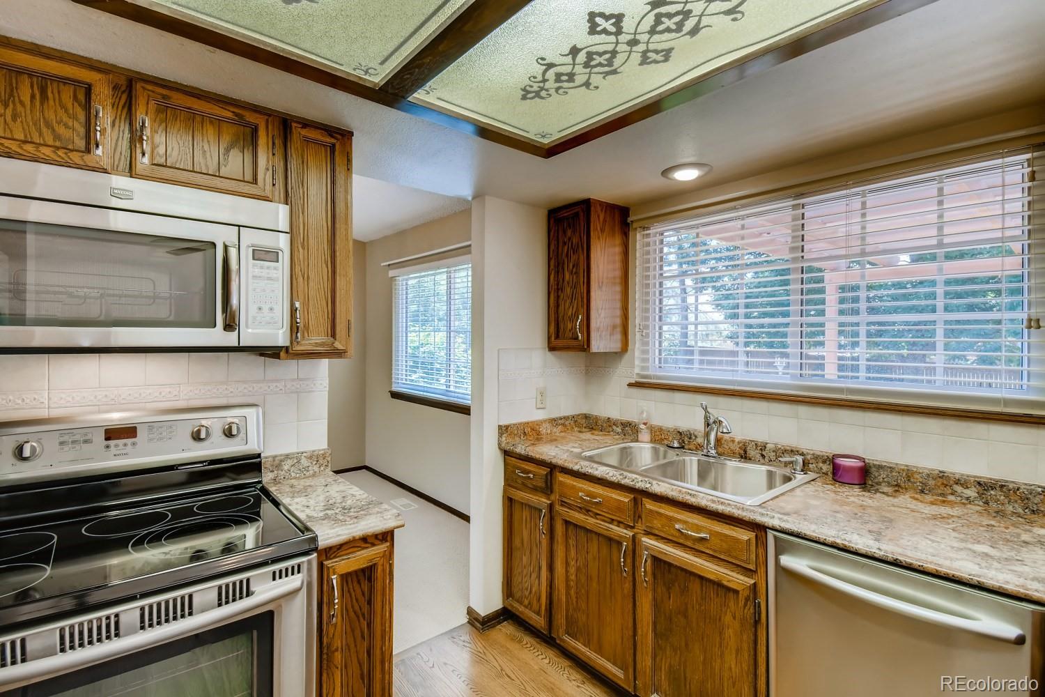 740 Prairie Ridge Road Highlands Ranch, CO 80126 - Photo 11 of 31 a kitchen with stainless steel appliances granite countertop a stove a sink and a microwave