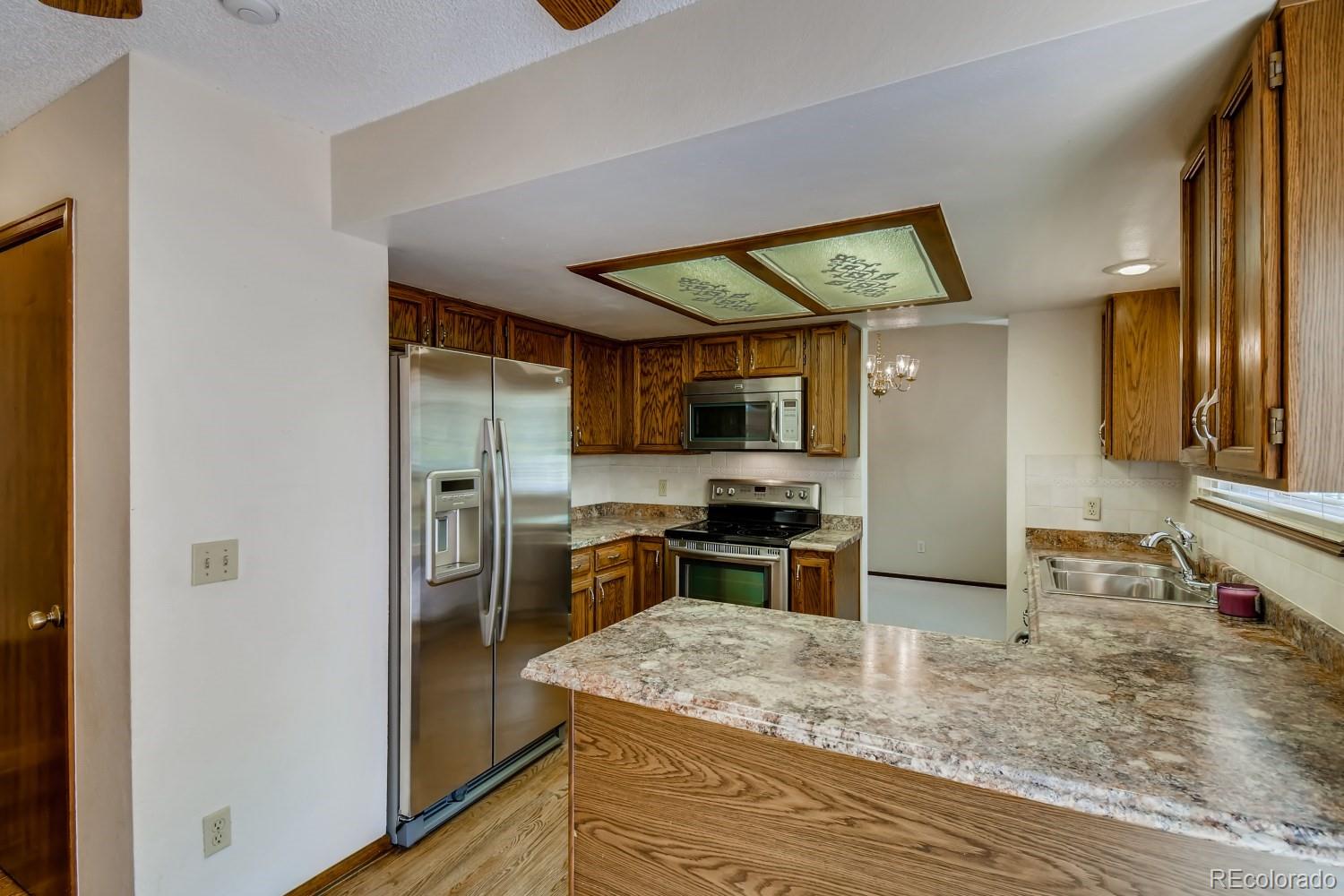740 Prairie Ridge Road Highlands Ranch, CO 80126 - Photo 12 of 31 a kitchen with stainless steel appliances granite countertop a sink stove and refrigerator
