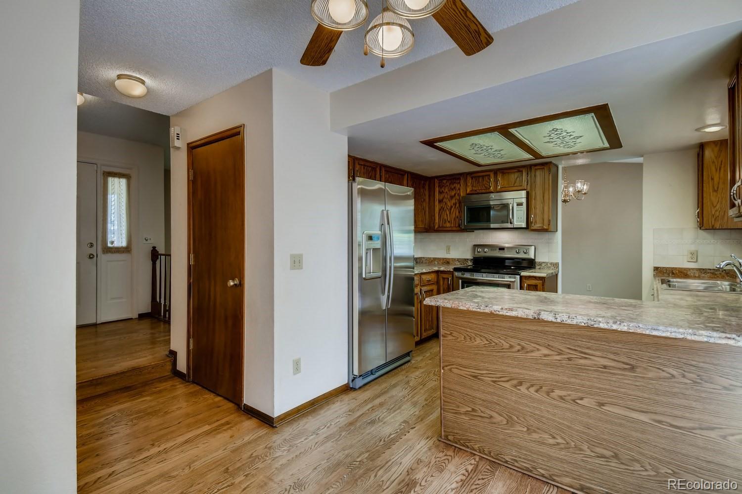 740 Prairie Ridge Road Highlands Ranch, CO 80126 - Photo 13 of 31 a kitchen with granite countertop a refrigerator and a sink