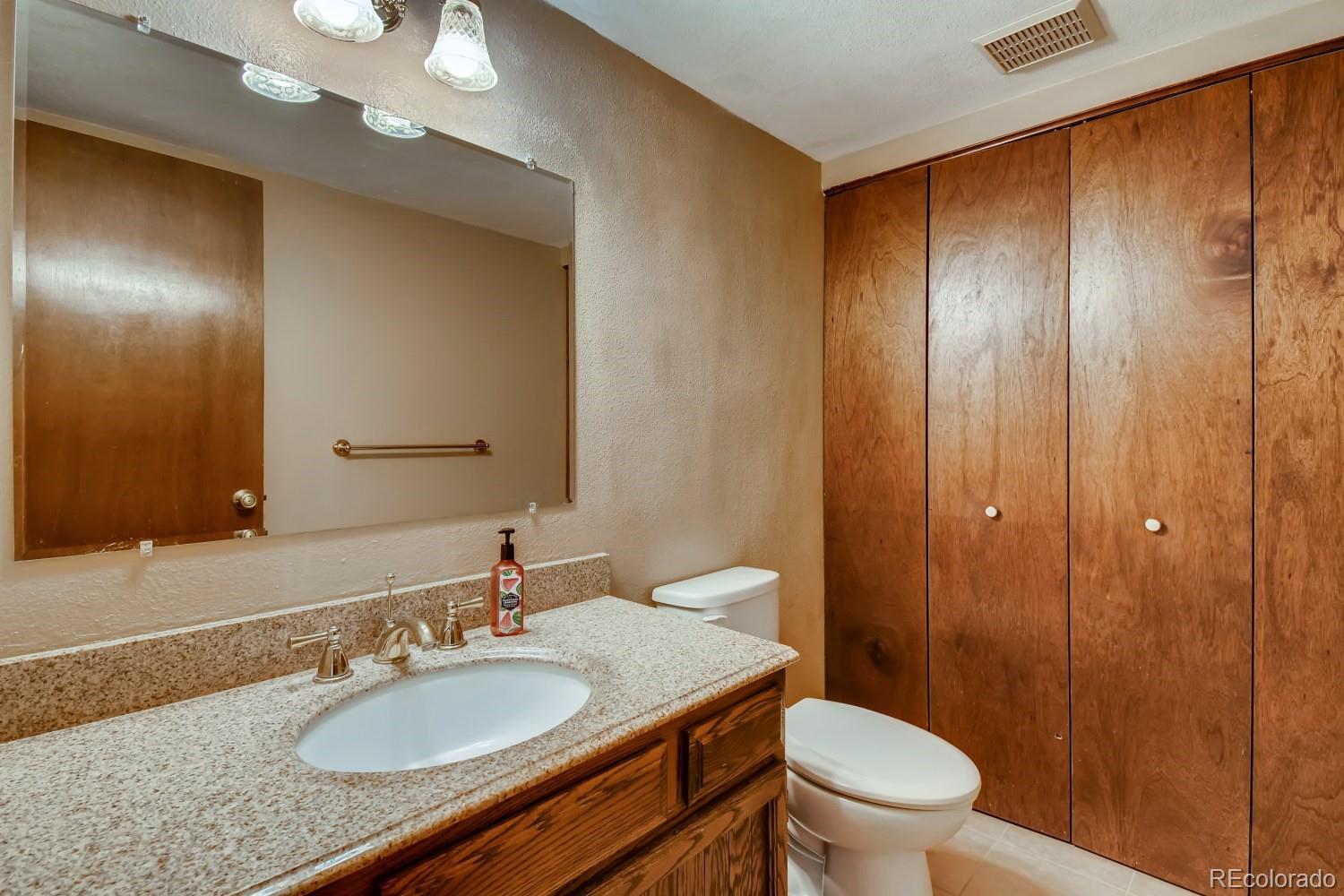 740 Prairie Ridge Road Highlands Ranch, CO 80126 - Photo 16 of 31 a bathroom with a granite countertop sink toilet and shower