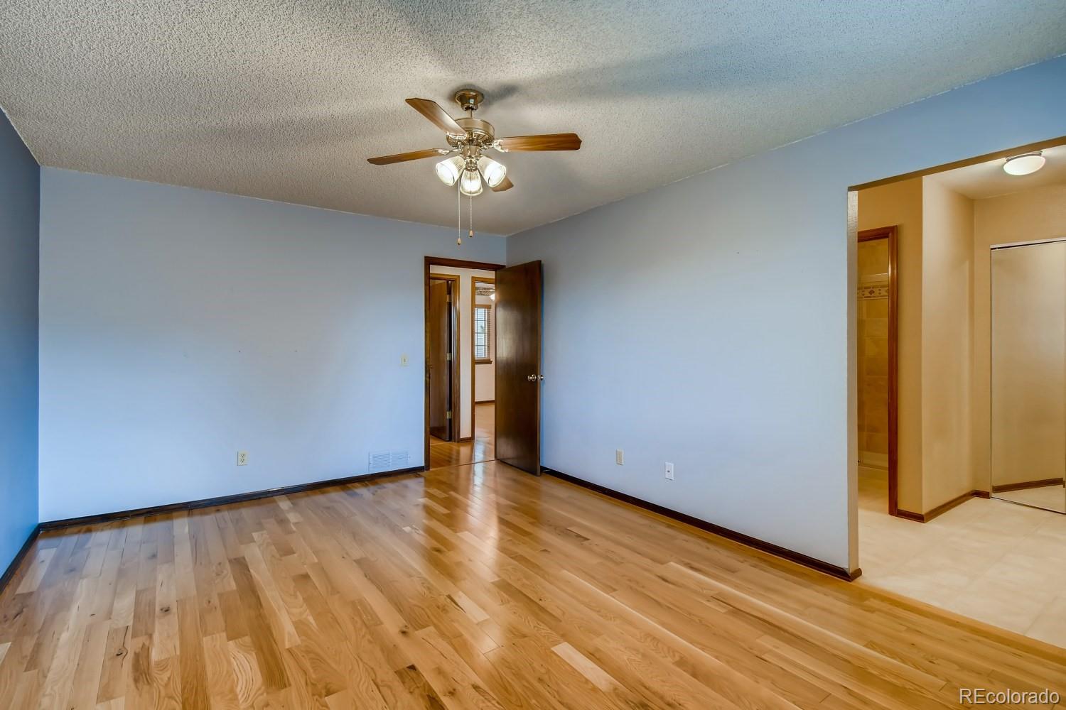 740 Prairie Ridge Road Highlands Ranch, CO 80126 - Photo 18 of 31 a view of an empty room with wooden floor and a chandelier fan