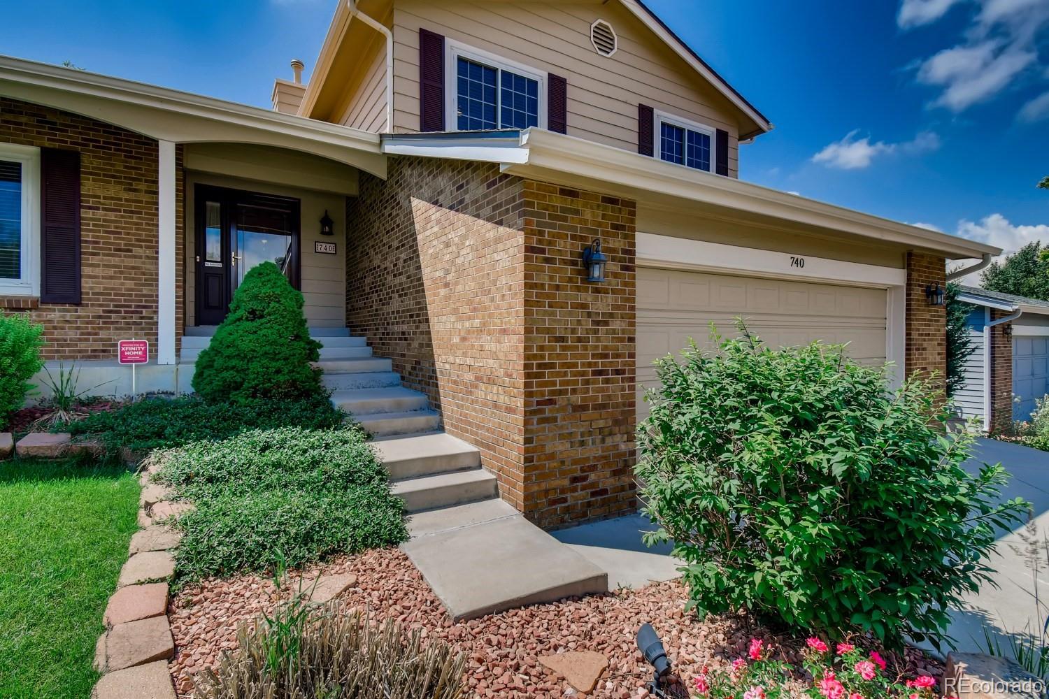 740 Prairie Ridge Road Highlands Ranch, CO 80126 - Photo 3 of 31 a front view of a house with garden