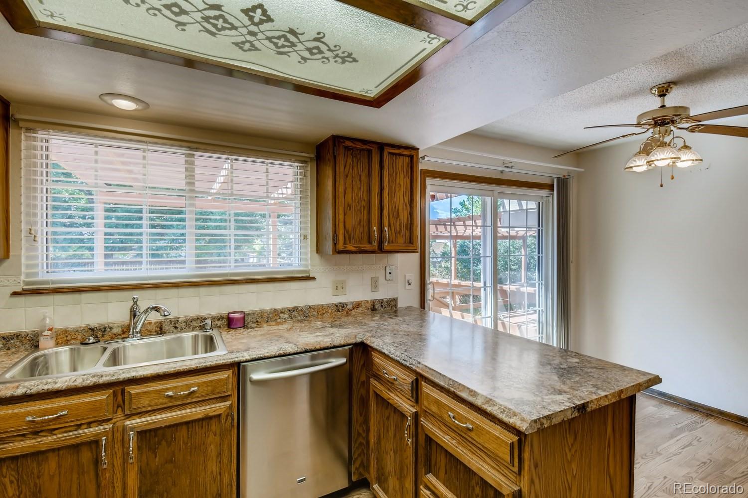 740 Prairie Ridge Road Highlands Ranch, CO 80126 - Photo 10 of 31 a kitchen with stainless steel appliances granite countertop a sink window and cabinets