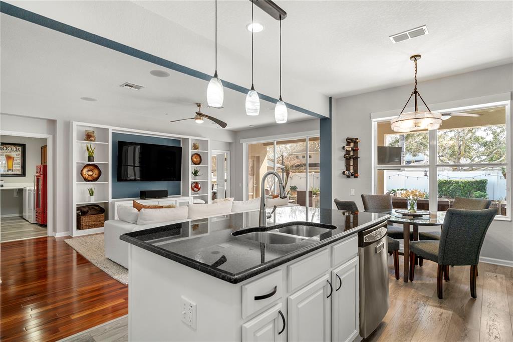 13320 Fernow Street Windermere, FL 34786 - Photo 13 of 52 a view of a dining room and livingroom with furniture wooden floor a rug a flat screen tv a rug a fireplace and a chandelier