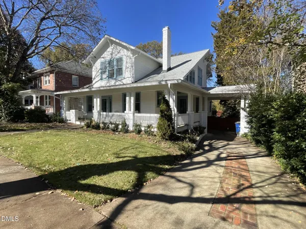 a front view of house with yard and trees around