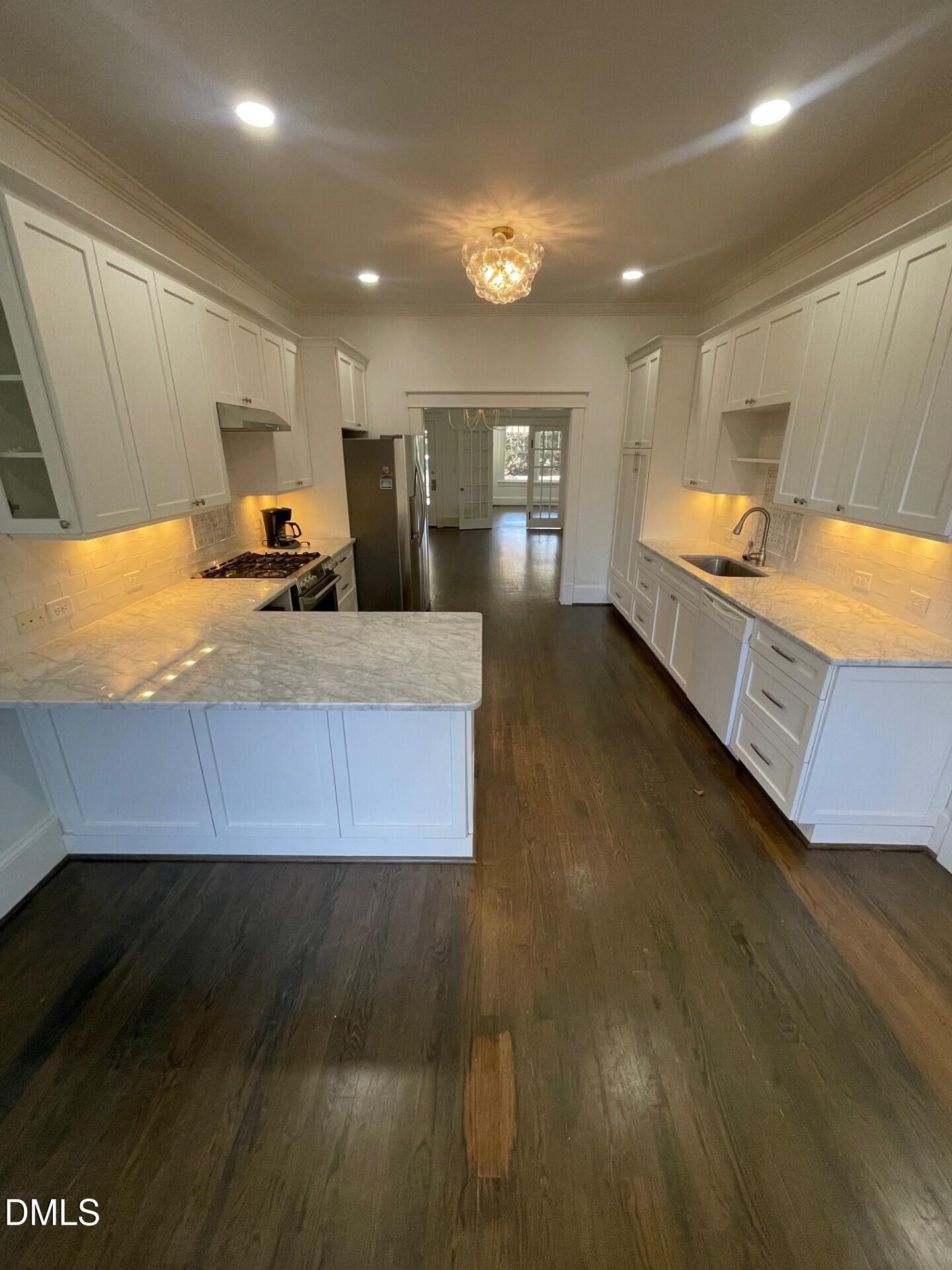 313 Calvin Road Raleigh, NC 27605 - Photo 12 of 39 a large kitchen with kitchen island a sink dishwasher a stove a dining table and a refrigerator with wooden floor