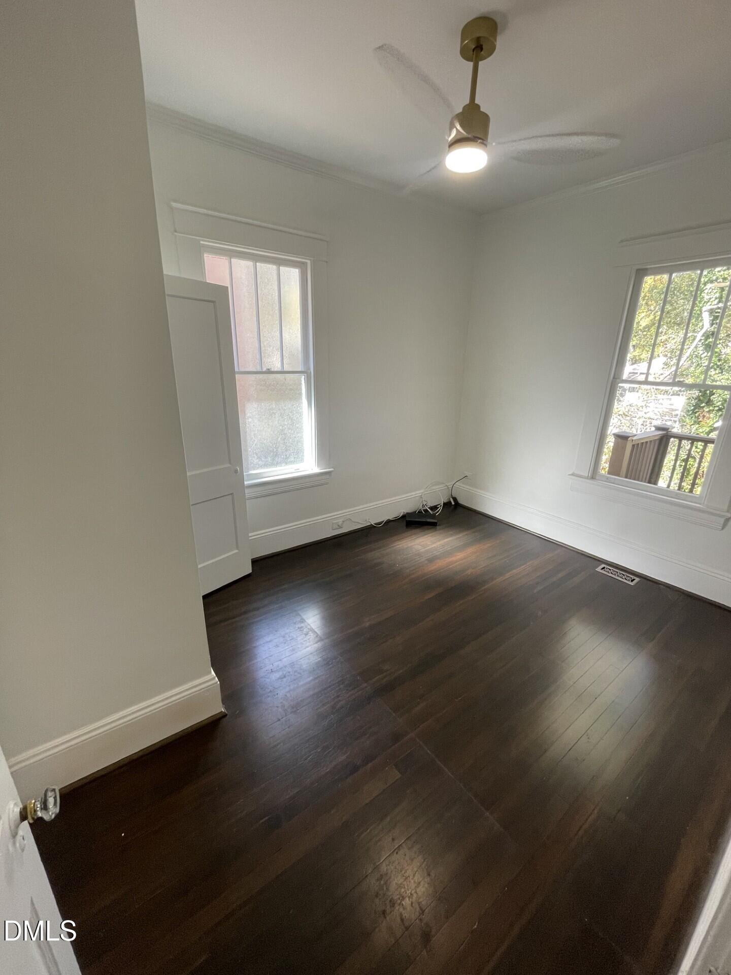 313 Calvin Road Raleigh, NC 27605 - Photo 19 of 39 an empty room with wooden floor fan and windows