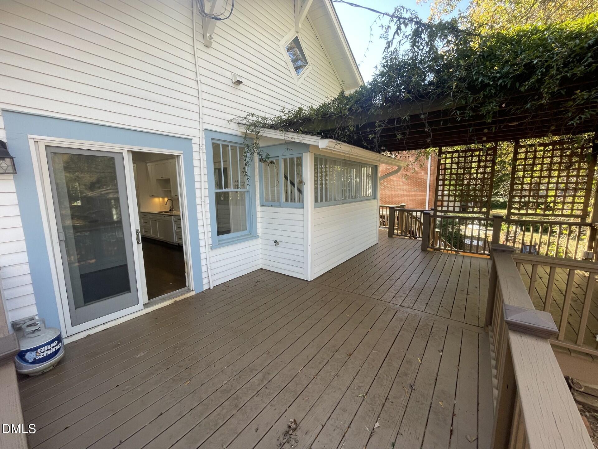313 Calvin Road Raleigh, NC 27605 - Photo 25 of 39 a view of a patio with table and chairs with wooden floor and fence